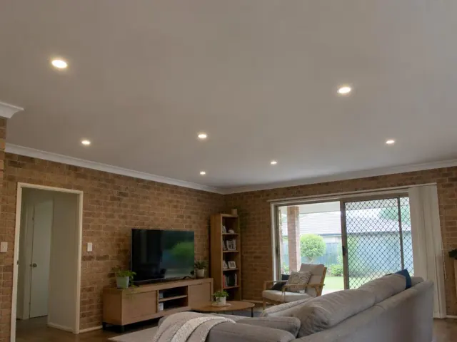 Living room with recessed downlights in a brick-walled home interior in Coomera